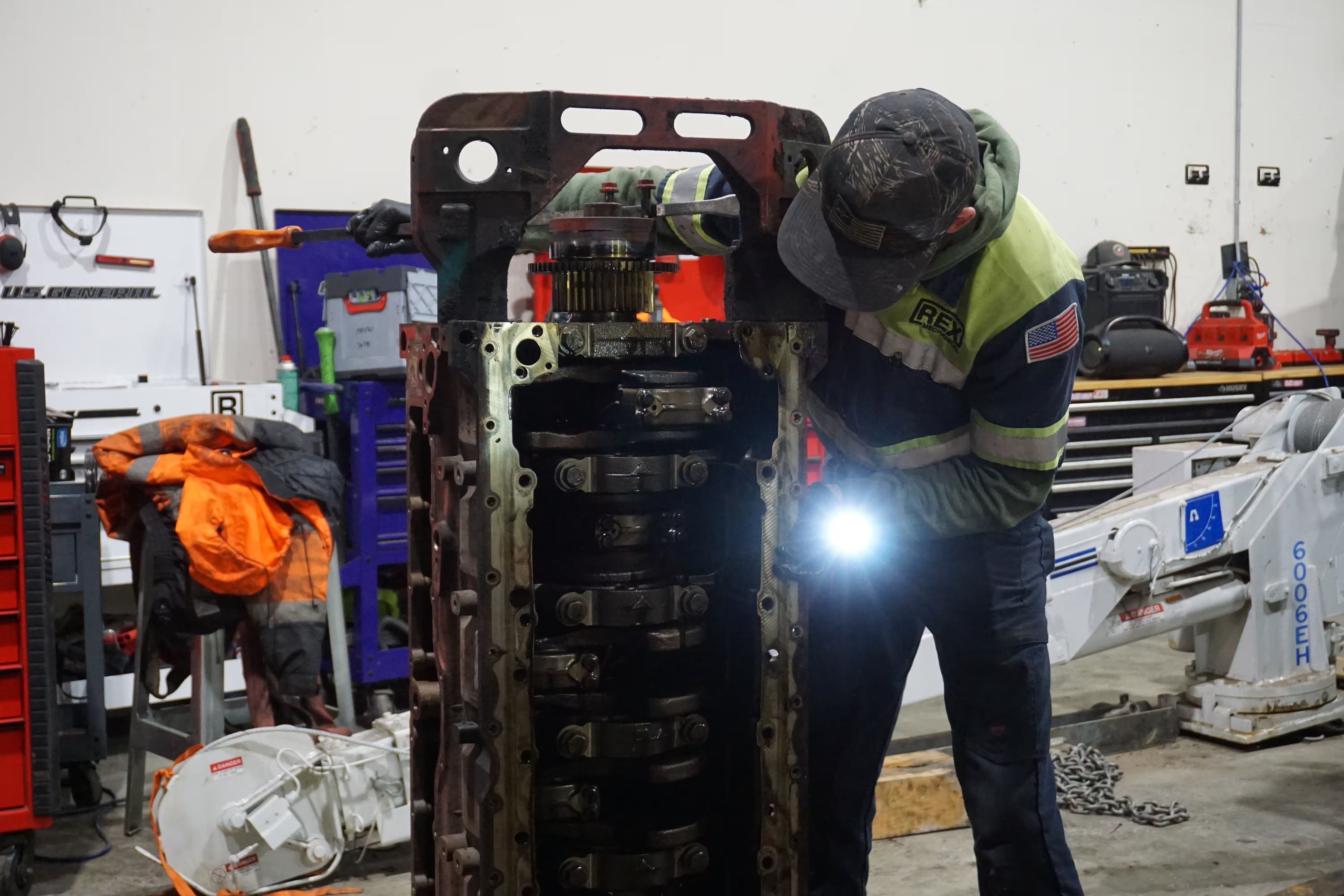 A technician inspects the main bearing caps of a diesel engine block